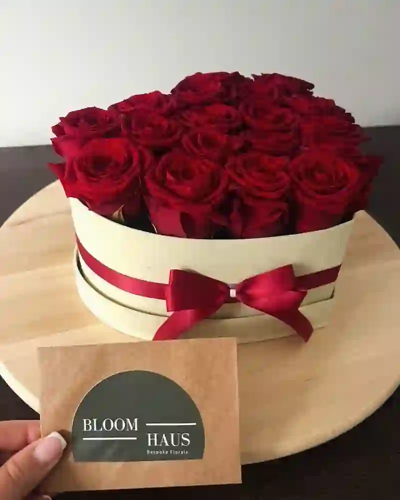 A luxury red rose gift box with a BloomHaus card